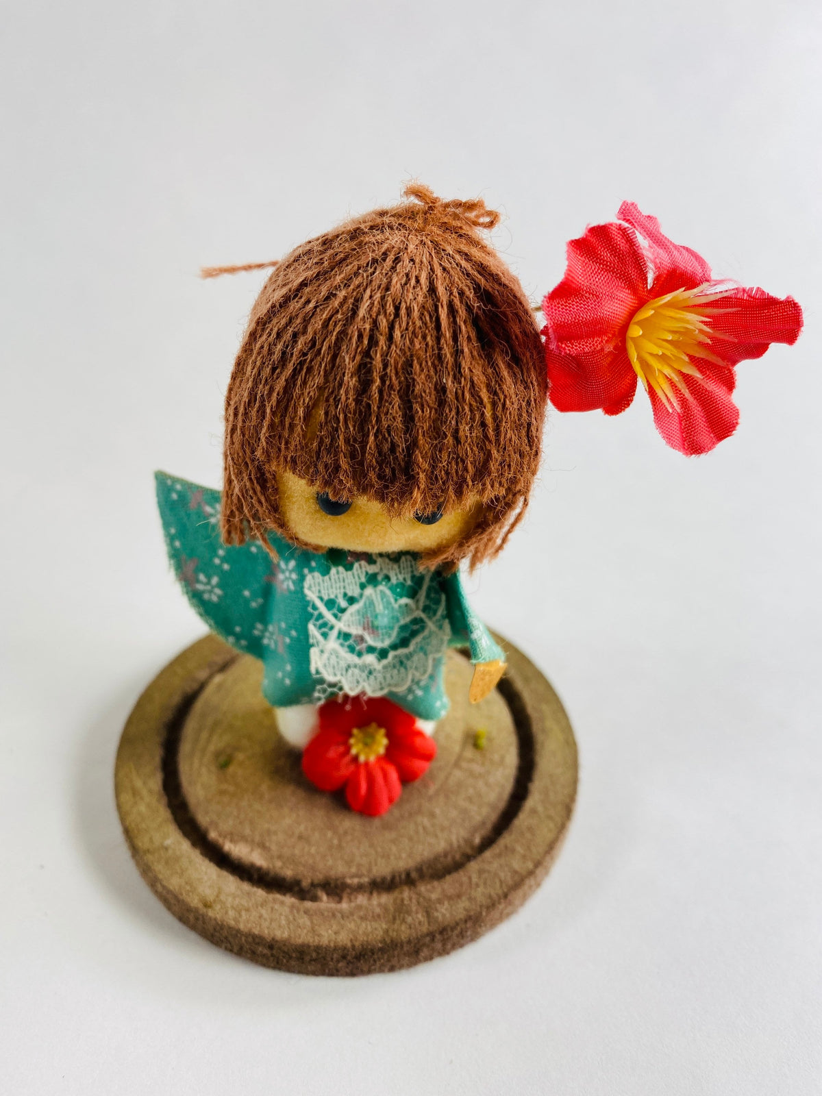 Vintage doll circa 1960s sad eyes felt girl long brown hair and pink orchid attached to round base Fisherman Aesthetic Maritime Living