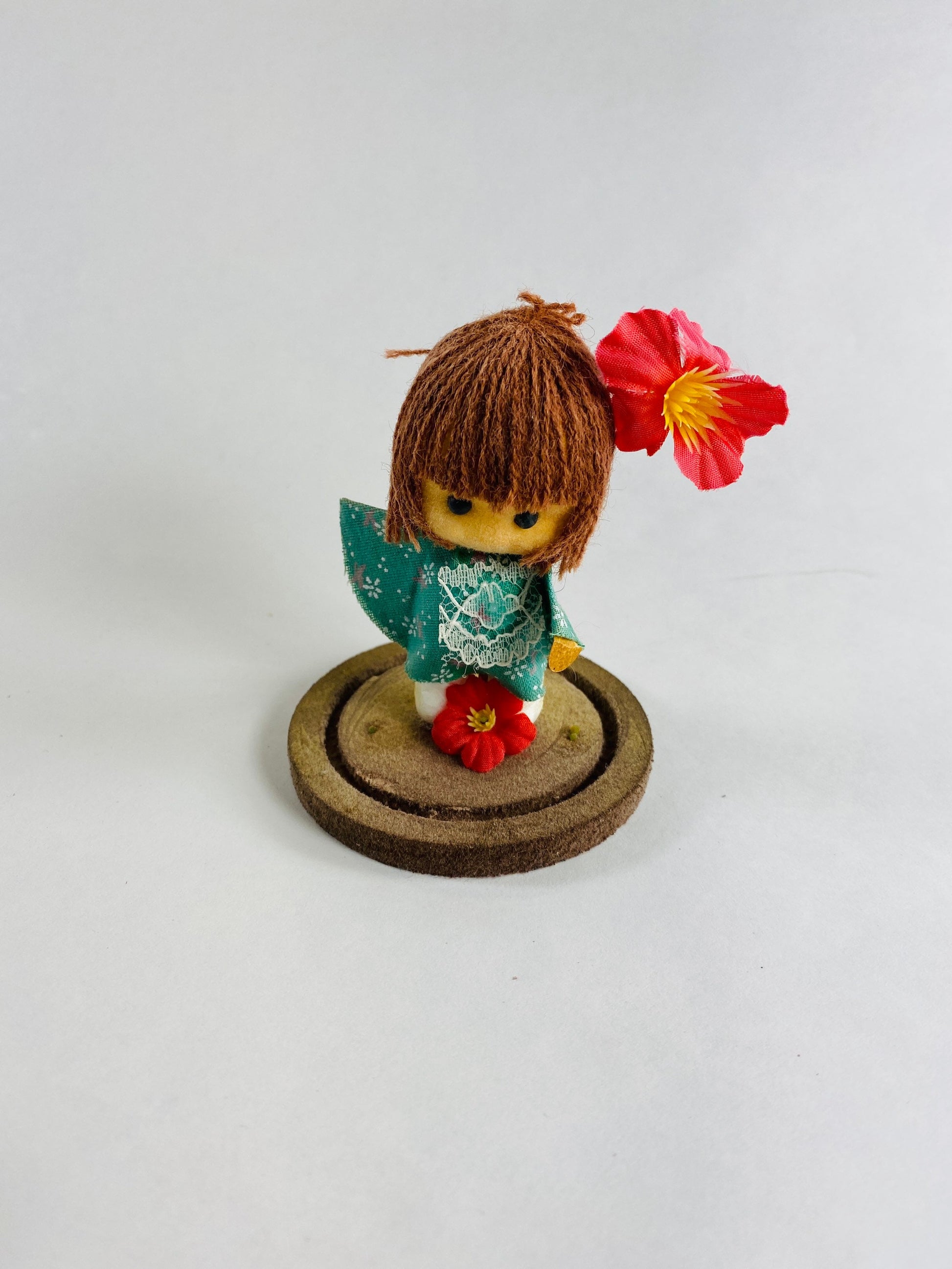 Vintage doll circa 1960s sad eyes felt girl long brown hair and pink orchid attached to round base Fisherman Aesthetic Maritime Living