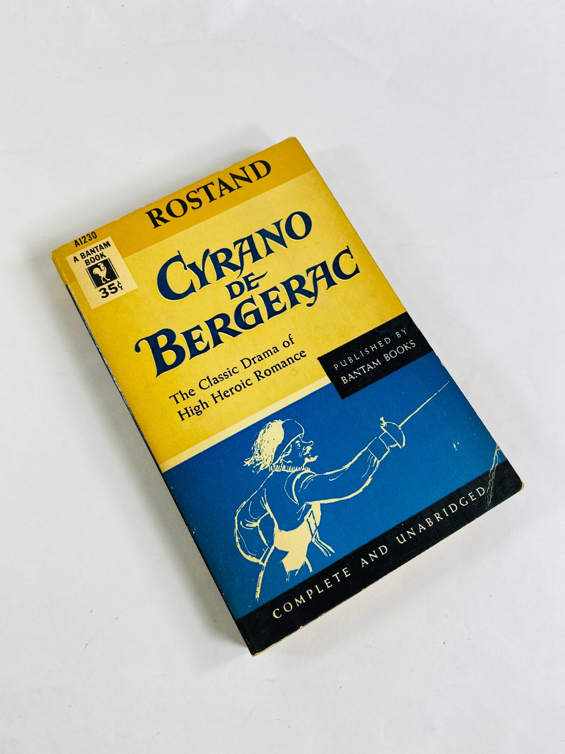 &quot;1954 vintage paperback of *Cyrano de Bergerac* by Edmond Rostand. Cover features an illustration of Cyrano with a large nose, dressed as a poet and swordsman. Classic story of love, self-doubt, and bravery.&quot;