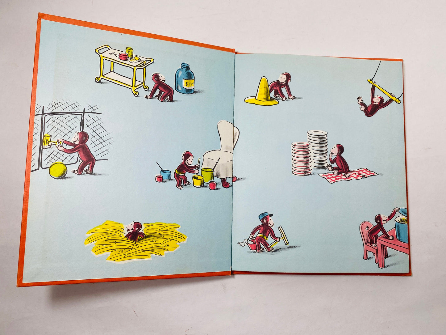 Curious George Gets a Job vintage children's book circa by HA Rey. Curious George vignette in red on yellow cloth. Houghton Mifflin 1975