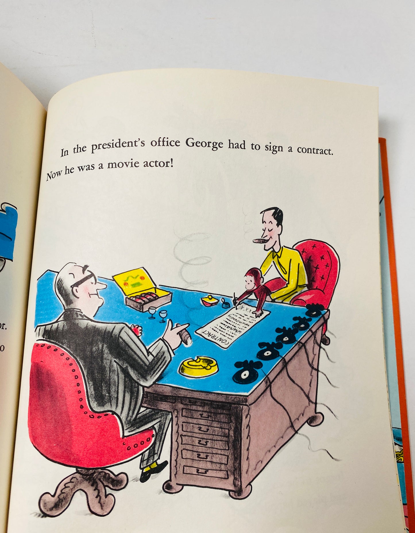 Curious George Gets a Job vintage children's book circa by HA Rey. Curious George vignette in red on yellow cloth. Houghton Mifflin 1975