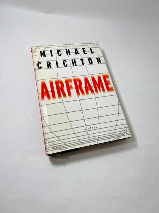 First edition vintage book Airframe by Michael Crichton, published circa 1996. The cover features an illustration of an airplane, depicting a thrilling investigation into a plane accident. A gripping tale of aviation safety and corporate intrigue