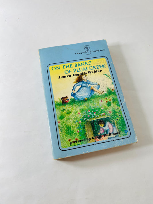 On the Banks of Plum Creek vintage paperback book circa 1971 by Laura Ingalls Wilder part of Little House on the Prairie series.